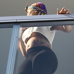 Exclusif - Blac Chyna enceinte, avec un t-shirt très court et sans soutien gorge, laisse entrevoir son ventre déjà bien rond et le dessous de ses seins au balcon de sa chambre d'hôtel à Miami, le 16 mai 2016