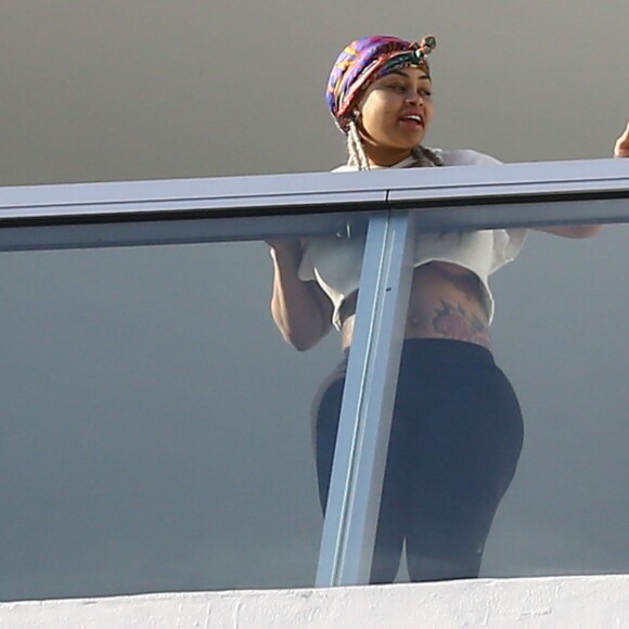 Exclusif - Blac Chyna enceinte, avec un t-shirt très court et sans soutien gorge, laisse entrevoir son ventre déjà bien rond et le dessous de ses seins au balcon de sa chambre d'hôtel à Miami, le 16 mai 2016