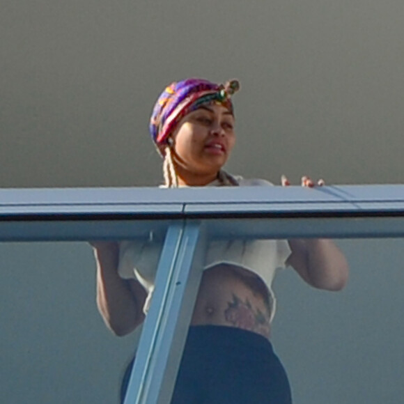 Exclusif - Blac Chyna enceinte, avec un t-shirt très court et sans soutien gorge, laisse entrevoir son ventre déjà bien rond et le dessous de ses seins au balcon de sa chambre d'hôtel à Miami, le 16 mai 2016