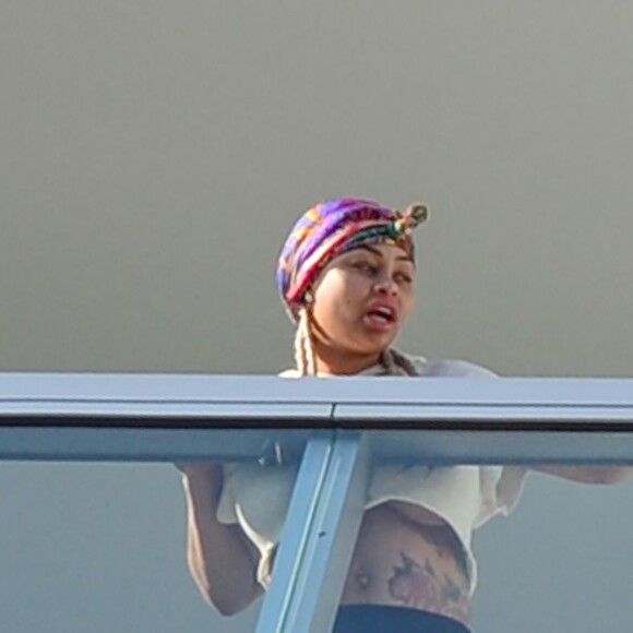 Exclusif - Blac Chyna enceinte, avec un t-shirt très court et sans soutien gorge, laisse entrevoir son ventre déjà bien rond et le dessous de ses seins au balcon de sa chambre d'hôtel à Miami, le 16 mai 2016
