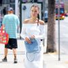 Bella Hadid de sortie à Los Angeles, porte une robe C/MEO Collective (modèle Life Is Real Long), un sac à dos matelassé Chanel et des baskets Nike (modèle Air Force 1). Le 3 août 2016.