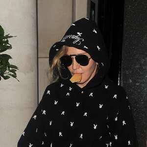 Madonna quitte une clinique avec un biscuit dans la bouche à Londres le 22 juin 2016.