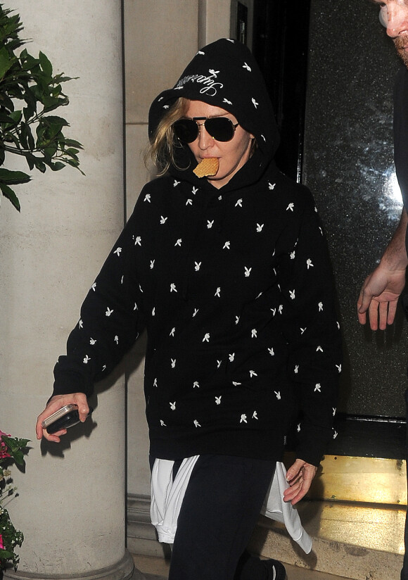 Madonna quitte une clinique avec un biscuit dans la bouche à Londres le 22 juin 2016.