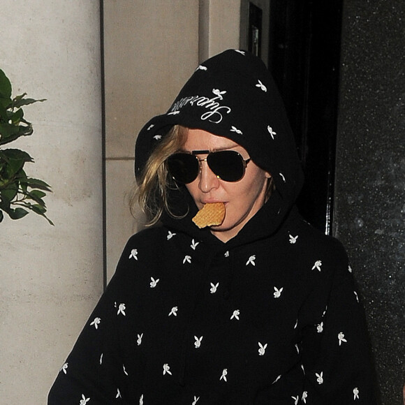 Madonna quitte une clinique avec un biscuit dans la bouche à Londres le 22 juin 2016.