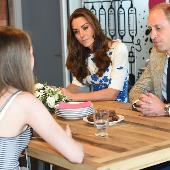 Le prince William et Kate Middleton, duc et duchesse de Cambridge, discutent avec deux adolescentes lors de leur visite dans les locaux de l'association Youthscape à Luton le 24 août 2016. Une journée de rentrée avec un accent mis sur la santé mentale, leur grande cause.