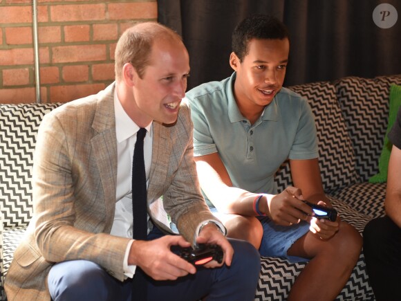 Le prince William fait une partie de FIFA avec des jeunes lors de sa visite avec Kate dans les locaux de l'association Youthscape à Luton le 24 août 2016. Une journée de rentrée avec un accent mis sur la santé mentale, leur grande cause.