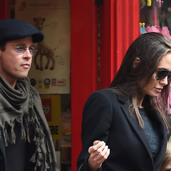 Brad Pitt, sa femme Angelina Jolie et leurs filles Vivienne et Zahara quittent un magasin de jouets à Londres le 12 mars 2016.