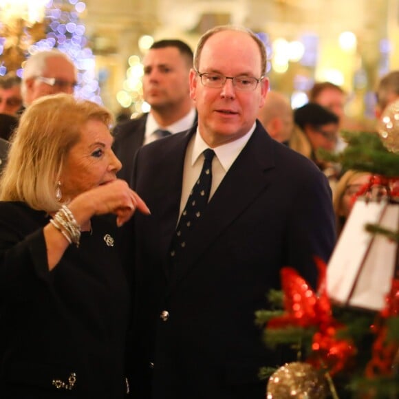 Le prince Albert II de Monaco accompagné par Louisette Levy-Soussan Azzoaglio, la présidente d'Action Innocence Monaco, pendant la traditionnelle vente aux enchères de Sapins de Noël de l'association spécialement créés et décorés pour l'occasion par de grandes marques, des boutiques et artisans de la Principauté le 14 décembre 2016 à Monaco.