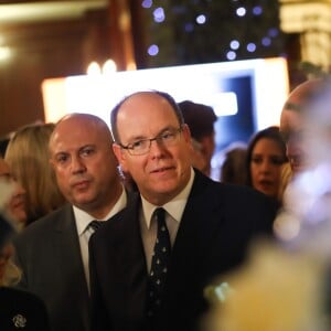 Le prince Albert II de Monaco accompagné par Louisette Levy-Soussan Azzoaglio, la présidente d'Action Innocence Monaco, pendant la traditionnelle vente aux enchères de Sapins de Noël de l'association spécialement créés et décorés pour l'occasion par de grandes marques, des boutiques et artisans de la Principauté le 14 décembre 2016 à Monaco.