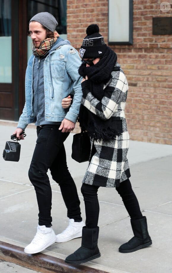 Margot Robbie se cache des photographes alors qu'elle monte dans un taxi avec son petit ami Tom Ackerley à New York, le 7 février 2016
