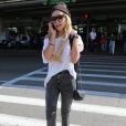 Amanda Bynes (sac Chanel) au téléphone à son arrivée à l'aéroport de Los Angeles, le 10 octobre 2014.
