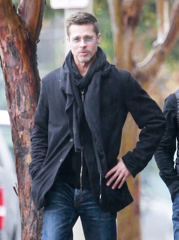 Brad Pitt et un ami bravent la pluie à Los Angeles pour aller vers un studio à pied le 23 janvier 2017.