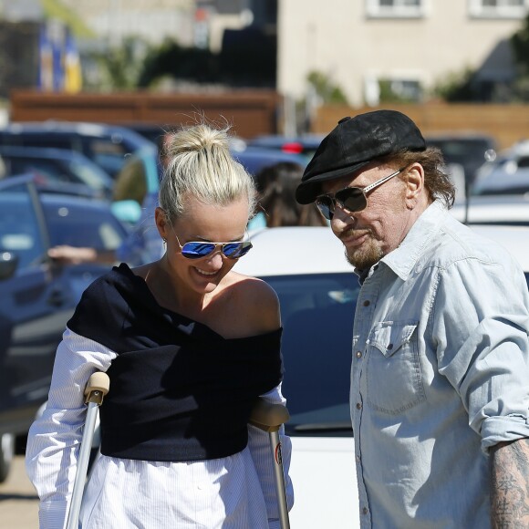 Johnny Hallyday avec sa femme Laeticia, qui marche toujours avec des béquilles, accompagnés de Maxim Nucci (Yodelice), arrivent au restaurant "Soho House" à Malibu, le 09 mars 2017.