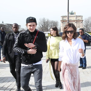 Victoria Beckham, son fils Brooklyn et le mannequin Sonia Ben Ammar devant la pyramide du Musée du Louvre à Paris. Le 11 mars 2017.