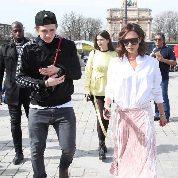 Victoria Beckham, son fils Brooklyn et le mannequin Sonia Ben Ammar devant la pyramide du Musée du Louvre à Paris. Le 11 mars 2017.