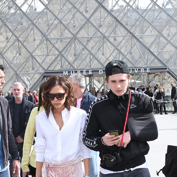 Victoria Beckham, son fils Brooklyn et le mannequin Sonia Ben Ammar devant la pyramide du Musée du Louvre à Paris. Le 11 mars 2017.