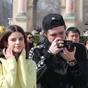 Victoria Beckham, son fils Brooklyn et le mannequin Sonia Ben Ammar devant la pyramide du Musée du Louvre à Paris. Le 11 mars 2017.