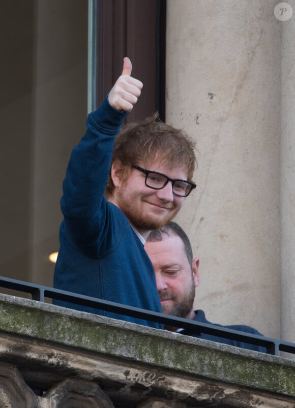 Ed Sheeran salue ses fans depuis le balcon Mondadori Megastore de la piazza del Duomo à Milan, le 12 mars 2017.