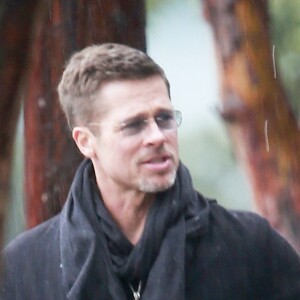 Exclusif - Brad Pitt et un ami bravent la pluie à Los Angeles pour aller vers un studio à pied le 23 janvier 2017.