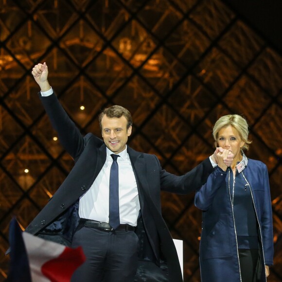 Emmanuel Macron, élu président de la république, et sa femme Brigitte Macron (Trogneux), saluent les militants devant la pyramide au musée du Louvre à Paris, après sa victoire lors du deuxième tour de l'élection présidentielle. Le 7 mai 2017.