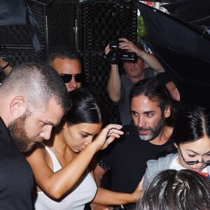 Kim Kardashian arrive chez un médecin à New York protégée par une très grosse équipe de sécurité le 11 juillet 2017. Elle porte un débardeur blanc transparent.