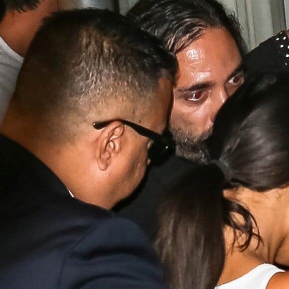 Kim Kardashian arrive chez un médecin à New York protégée par une très grosse équipe de sécurité le 11 juillet 2017. Elle porte un débardeur blanc transparent.