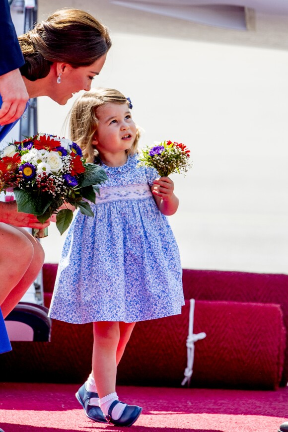 La princesse Charlotte avec son mini-bouquet de fleurs offert par le gouvernement allemand. Arrivée du prince William et de Kate Middleton avec leurs enfants George et Charlotte de Cambridge à l'aéroport de Berlin-Tegel en Allemagne le 19 juillet 2017 lors de leur visite officielle.