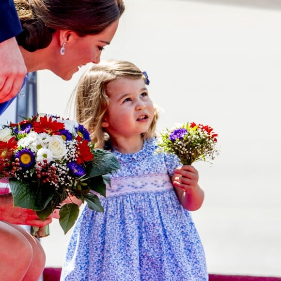 La princesse Charlotte avec son mini-bouquet de fleurs offert par le gouvernement allemand. Arrivée du prince William et de Kate Middleton avec leurs enfants George et Charlotte de Cambridge à l'aéroport de Berlin-Tegel en Allemagne le 19 juillet 2017 lors de leur visite officielle.