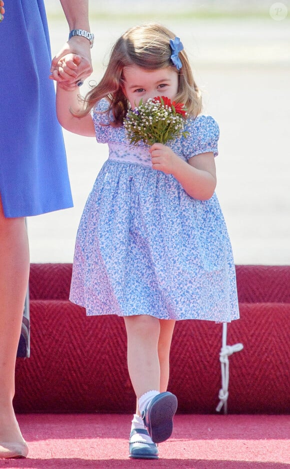 Charlotte de Cambridge était ravie de son mini-bouquet. Arrivée du prince William et de Kate Middleton avec leurs enfants George et Charlotte de Cambridge à l'aéroport de Berlin-Tegel en Allemagne le 19 juillet 2017 lors de leur visite officielle.