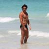 Gregory Basso, mieux connu sous le nom de Greg le Millionnaire, est à la plage à Miami avec une amie, entouré de cameramen le 1er aout 2011.