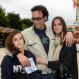 Anthony Delon et ses filles Lou et Liv lors de l'inauguration de la fête foraine des Tuileries à Paris le 28 juin 2013