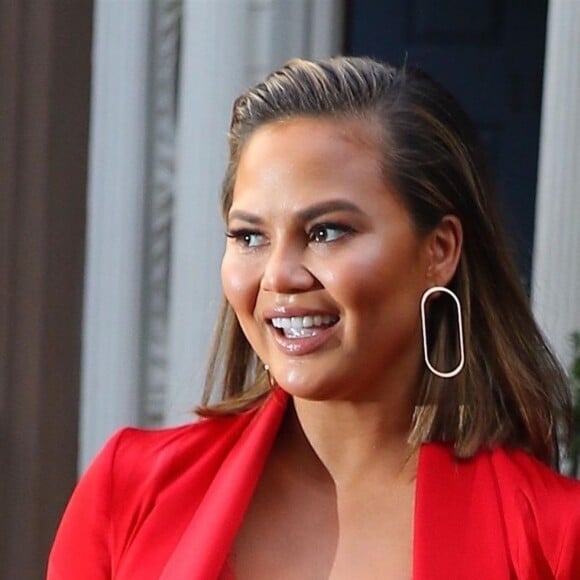 Chrissy Teigen (enceinte) porte une robe rouge style nuisette sans soutien-gorge à la sortie de son domicile à New York, le 30 janvier 2018