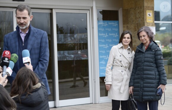 La reine Letizia et la reine Sofia d'Espagne à l'entrée de l'hôpital La Moraleja dans le nord de Madrid le 7 avril 2018, attendant que le roi Felipe VI ait fini de parler à la presse, lors de leur visite au roi Juan Carlos Ier, hospitalisé pour le remplacement de la prothèse de son genou droit.