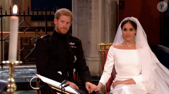Mariage du prince Harry et de Meghan Markle le 19 mai 2018, main dans la main en la chapelle St George à Windsor. Meghan porte une robe de mariée confectionnée par Clare Waight Keller pour Givenchy, Harry porte son uniforme de capitaine des Blues and Royals.