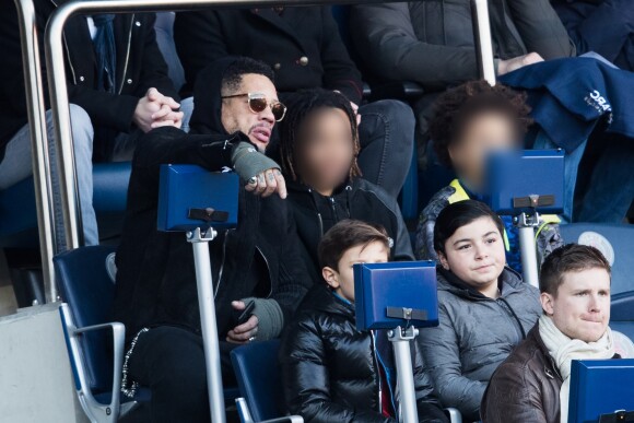 JoeyStarr et ses deux fils Mathis et Khalil dans les tribunes du match PSG - Strasbourg (5-2) au Parc des Princes à Paris le 17 février 2018.