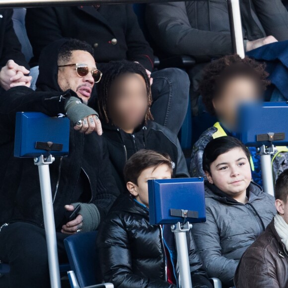 JoeyStarr et ses deux fils Mathis et Khalil dans les tribunes du match PSG - Strasbourg (5-2) au Parc des Princes à Paris le 17 février 2018.