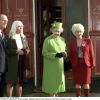 Barbara Windsor (en tailleur rouge) recevant la visite de la reine Elizabeth II et du duc d'Edimbourg sur le tournage du soap opera EastEnders en novembre 2001 à Londres.