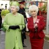 Barbara Windsor (en tailleur rouge) recevant la visite de la reine Elizabeth II et du duc d'Edimbourg sur le tournage du soap opera EastEnders en novembre 2001 à Londres.