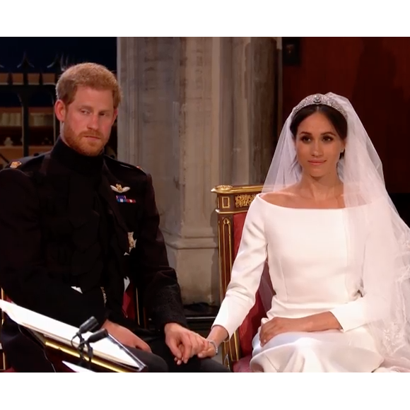 Mariage du prince Harry et de Meghan Markle le 19 mai 2018, main dans la main en la chapelle St George à Windsor. Meghan porte une robe de mariée confectionnée par Clare Waight Keller pour Givenchy, Harry porte son uniforme de capitaine des Blues and Royals.