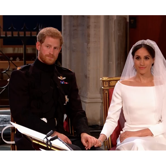 Mariage du prince Harry et de Meghan Markle le 19 mai 2018, main dans la main en la chapelle St George à Windsor. Meghan porte une robe de mariée confectionnée par Clare Waight Keller pour Givenchy, Harry porte son uniforme de capitaine des Blues and Royals.