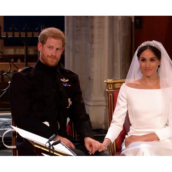 Mariage du prince Harry et de Meghan Markle le 19 mai 2018, main dans la main en la chapelle St George à Windsor. Meghan porte une robe de mariée confectionnée par Clare Waight Keller pour Givenchy, Harry porte son uniforme de capitaine des Blues and Royals.