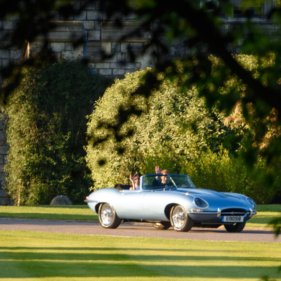 Le prince Harry, duc de Sussex, et Meghan Markle, duchesse de Sussex, habillée d'une robe Stella McCartney et portant une bague sertie d'une aigue-marine ayant appartenu à Lady Diana, ont quitté le château de Windsor après la réception offerte par Elizabeth II pour rejoindre à bord d'une Jaguar E-Type Concept Zero immatriculée "190518" Frogmore House où avait lieu la réception de leur mariage, le 19 mai 2018.