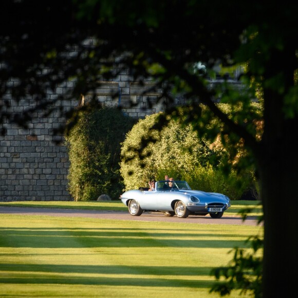 Le prince Harry, duc de Sussex, et Meghan Markle, duchesse de Sussex, habillée d'une robe Stella McCartney et portant une bague sertie d'une aigue-marine ayant appartenu à Lady Diana, ont quitté le château de Windsor après la réception offerte par Elizabeth II pour rejoindre à bord d'une Jaguar E-Type Concept Zero immatriculée "190518" Frogmore House où avait lieu la réception de leur mariage, le 19 mai 2018.