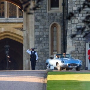 Le prince Harry, duc de Sussex, et Meghan Markle, duchesse de Sussex, habillée d'une robe Stella McCartney et portant une bague sertie d'une aigue-marine ayant appartenu à Lady Diana, ont quitté le château de Windsor après la réception offerte par Elizabeth II pour rejoindre à bord d'une Jaguar E-Type Concept Zero immatriculée "190518" Frogmore House où avait lieu la réception de leur mariage, le 19 mai 2018.