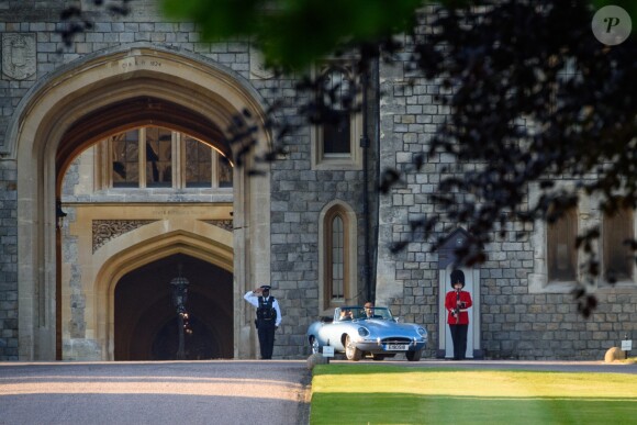 Le prince Harry, duc de Sussex, et Meghan Markle, duchesse de Sussex, habillée d'une robe Stella McCartney et portant une bague sertie d'une aigue-marine ayant appartenu à Lady Diana, ont quitté le château de Windsor après la réception offerte par Elizabeth II pour rejoindre à bord d'une Jaguar E-Type Concept Zero immatriculée "190518" Frogmore House où avait lieu la réception de leur mariage, le 19 mai 2018.