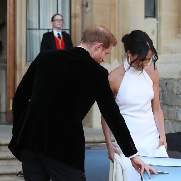 Le prince Harry, duc de Sussex, et Meghan Markle, duchesse de Sussex, habillée d'une robe Stella McCartney et portant une bague sertie d'une aigue-marine ayant appartenu à Lady Diana, quittant le château de Windsor après la réception offerte par Elizabeth II pour rejoindre à bord d'une Jaguar E-Type Concept Zero immatriculée "190518" Frogmore House où avait lieu la réception de leur mariage, le 19 mai 2018.