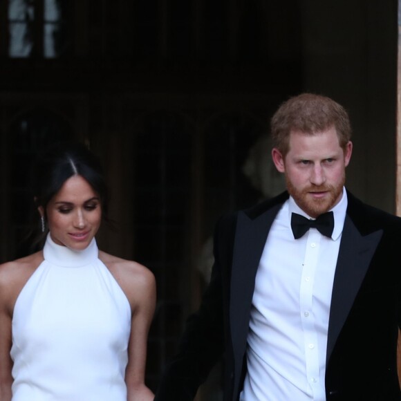 Le prince Harry, duc de Sussex, et Meghan Markle, duchesse de Sussex, habillée d'une robe Stella McCartney et portant une bague sertie d'une aigue-marine ayant appartenu à Lady Diana, quittant le château de Windsor après la réception offerte par Elizabeth II pour rejoindre à bord d'une Jaguar E-Type Concept Zero immatriculée "190518" Frogmore House où avait lieu la réception de leur mariage, le 19 mai 2018.