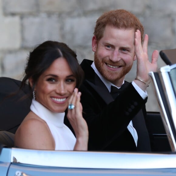 Le prince Harry, duc de Sussex, et Meghan Markle, duchesse de Sussex, habillée d'une robe Stella McCartney et portant une bague sertie d'une aigue-marine ayant appartenu à Lady Diana, quittant le château de Windsor après la réception offerte par Elizabeth II pour rejoindre à bord d'une Jaguar E-Type Concept Zero immatriculée "190518" Frogmore House où avait lieu la réception de leur mariage, le 19 mai 2018.