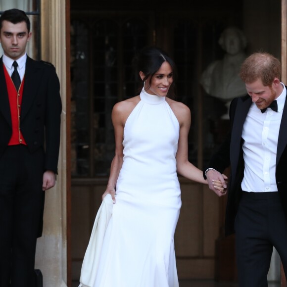 Le prince Harry, duc de Sussex, et Meghan Markle, duchesse de Sussex, habillée d'une robe Stella McCartney et portant une bague sertie d'une aigue-marine ayant appartenu à Lady Diana, quittant le château de Windsor après la réception offerte par Elizabeth II pour rejoindre à bord d'une Jaguar E-Type Concept Zero immatriculée "190518" Frogmore House où avait lieu la réception de leur mariage, le 19 mai 2018.