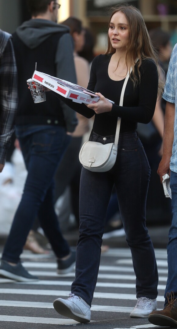 Lily Rose Depp se balade dans le quartier de Soho une pizza et un soda à emporter dans les main à New York, le 30 mai 2018 L